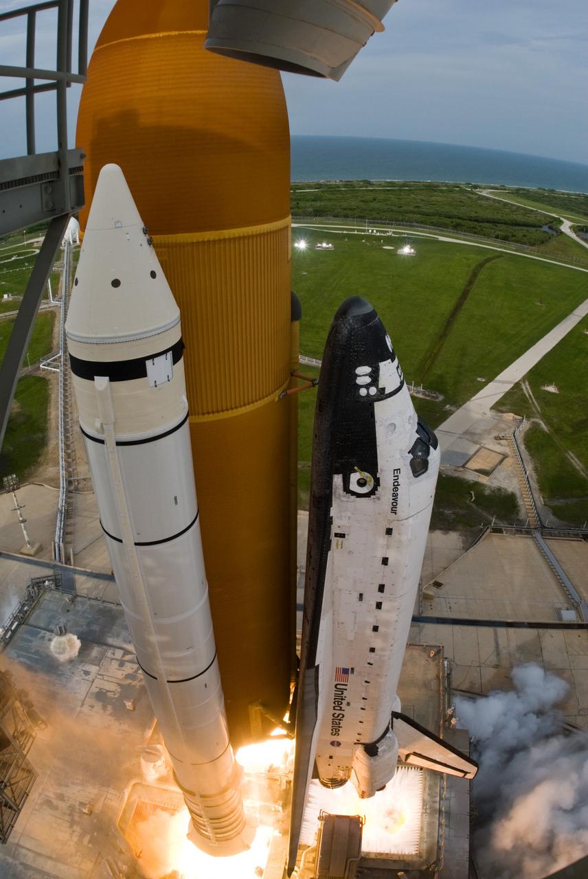 CAPE CANAVERAL, Fla. – A fish-eye view captures this close view of space shuttle Endeavour as it leaps from NASA Kennedy Space Center's Launch Pad 39A on the STS-127 mission.  Liftoff was on-time at 6:03 p.m. EDT. Today was the sixth launch attempt for the STS-127 mission.  The launch was scrubbed on June 13 and June 17 when a hydrogen gas leak occurred during tanking due to a misaligned Ground Umbilical Carrier Plate.  The mission was postponed July 11, 12 and 13 due to weather conditions near the Shuttle Landing Facility at Kennedy that violated rules for launching, and lightning issues. Endeavour will deliver the Japanese Experiment Module's Exposed Facility and the Experiment Logistics Module-Exposed Section in the final of three flights dedicated to the assembly of the Japan Aerospace Exploration Agency's Kibo laboratory complex on the International Space Station.   Photo credit: NASA/Tony Gray, Tom Farrar