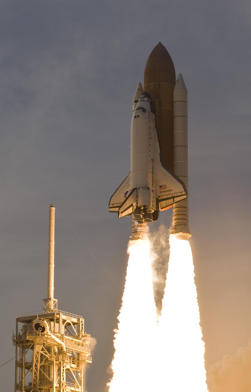 CAPE CANAVERAL, Fla. – Propelled by columns of fire, space shuttle Endeavour races past the lightning mast on the fixed service structure of NASA ennedy Space Center's Launch Pad 39A as it heads for space on the STS-127 mission. Liftoff was on-time at 6:03 p.m. EDT. This was the sixth launch attempt for the STS-127 mission.  The launch was scrubbed on June 13 and June 17 when a hydrogen gas leak occurred during tanking due to a misaligned Ground Umbilical Carrier Plate.  The mission was postponed July 11, 12 and 13 due to weather conditions near the Shuttle Landing Facility at Kennedy that violated rules for launching, and lightning issues. Endeavour will deliver the Japanese Experiment Module's Exposed Facility and the Experiment Logistics Module-Exposed Section in the final of three flights dedicated to the assembly of the Japan Aerospace Exploration Agency's Kibo laboratory complex on the International Space Station.   Photo courtesy of Scott Andrews