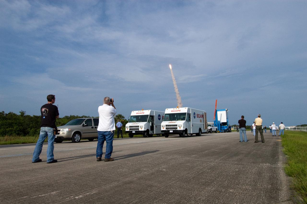 CAPE CANAVERAL, Fla. – At NASA Kennedy Space Center's Shuttle Landing Facility, employees capture the successful launch of space shuttle Endeavour on the STS-127 mission.  At the SLF are SCAPE vehicles, which stand by in the event a return-to-landing-site is needed after launch. Liftoff was on-time at 6:03 p.m. EDT. This was the sixth launch attempt for the STS-127 mission.  The launch was scrubbed on June 13 and June 17 when a hydrogen gas leak occurred during tanking due to a misaligned Ground Umbilical Carrier Plate.  The mission was postponed July 11, 12 and 13 due to weather conditions near the Shuttle Landing Facility at Kennedy that violated rules for launching, and lightning issues. Endeavour will deliver the Japanese Experiment Module's Exposed Facility and the Experiment Logistics Module-Exposed Section in the final of three flights dedicated to the assembly of the Japan Aerospace Exploration Agency's Kibo laboratory complex on the International Space Station.   Photo credit: NASA/Chuck Tintera