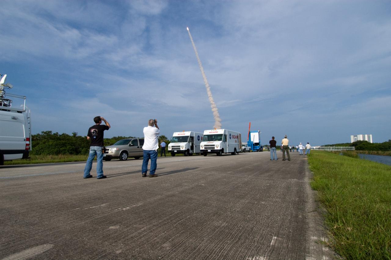 CAPE CANAVERAL, Fla. – At NASA Kennedy Space Center's Shuttle Landing Facility, employees capture the successful launch of space shuttle Endeavour on the STS-127 mission.  At the SLF are SCAPE vehicles, which stand by in the event a return-to-landing-site is needed after launch. Liftoff was on-time at 6:03 p.m. EDT. This was the sixth launch attempt for the STS-127 mission.  The launch was scrubbed on June 13 and June 17 when a hydrogen gas leak occurred during tanking due to a misaligned Ground Umbilical Carrier Plate.  The mission was postponed July 11, 12 and 13 due to weather conditions near the Shuttle Landing Facility at Kennedy that violated rules for launching, and lightning issues. Endeavour will deliver the Japanese Experiment Module's Exposed Facility and the Experiment Logistics Module-Exposed Section in the final of three flights dedicated to the assembly of the Japan Aerospace Exploration Agency's Kibo laboratory complex on the International Space Station.   Photo credit: NASA/Chuck Tintera