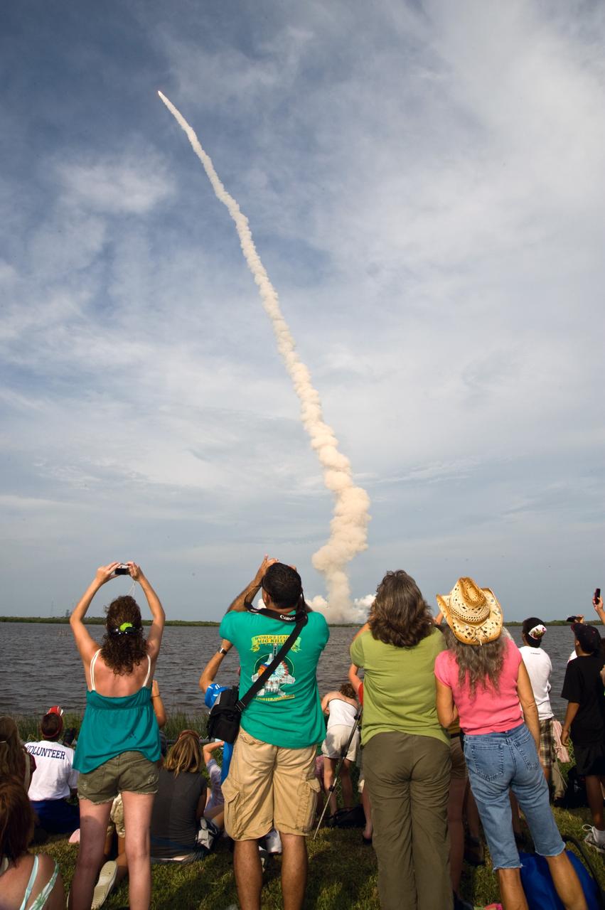 CAPE CANAVERAL, Fla. – Spectators at the NASA Kennedy Space Center's Banana River viewing site lean for better views of space shuttle Endeavour as it roars into space on the STS-127 mission. Liftoff was on-time at 6:03 p.m. EDT.  This was the sixth launch attempt for the STS-127 mission.  The launch was scrubbed on June 13 and June 17 when a hydrogen gas leak occurred during tanking due to a misaligned Ground Umbilical Carrier Plate.  The mission was postponed July 11, 12 and 13 due to weather conditions near the Shuttle Landing Facility at Kennedy that violated rules for launching, and lightning issues. Endeavour will deliver the Japanese Experiment Module's Exposed Facility and the Experiment Logistics Module-Exposed Section in the final of three flights dedicated to the assembly of the Japan Aerospace Exploration Agency's Kibo laboratory complex on the International Space Station.   Photo credit: NASA/Ben Cooper