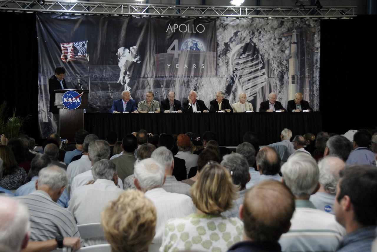 CAPE CANAVERAL, Fla. –  With CNN correspondent John Zarella (left) moderating, Apollo astronauts (at the dais) Buzz Aldrin, Walt Cunningham, Edgar Mitchell, Al Worden, Charlie Duke, Vance Brand, Gerald Carr and Bruce McCandless share stories of their experiences during NASA's 40th Anniversary of Apollo Celebration of the July 1969 launch and landing on the moon.  The ceremony was held in the Apollo/Saturn V Center at NASA's Kennedy Space Center in Florida.  Photo credit: NASA/Kim Shiflett