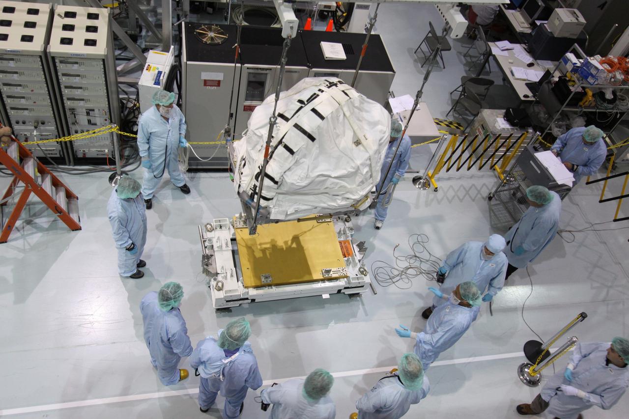 CAPE CANAVERAL, Fla. – In the Space Station Processing Facility at NASA's Kennedy Space Center in Florida,  technicians keep watch as the control moment gyroscope is lifted from its stand.  It will be moved to an EXPRESS Logistics Carrier.  The carrier is part of the STS-129 payload on space shuttle Atlantis, which will deliver to the International Space Station two spare gyroscopes, two nitrogen tank assemblies, two pump modules, an ammonia tank assembly and a spare latching end effector for the station's robotic arm.  STS-129 is targeted to launch Nov. 12 .  Photo credit: NASA/Jack Pfaller