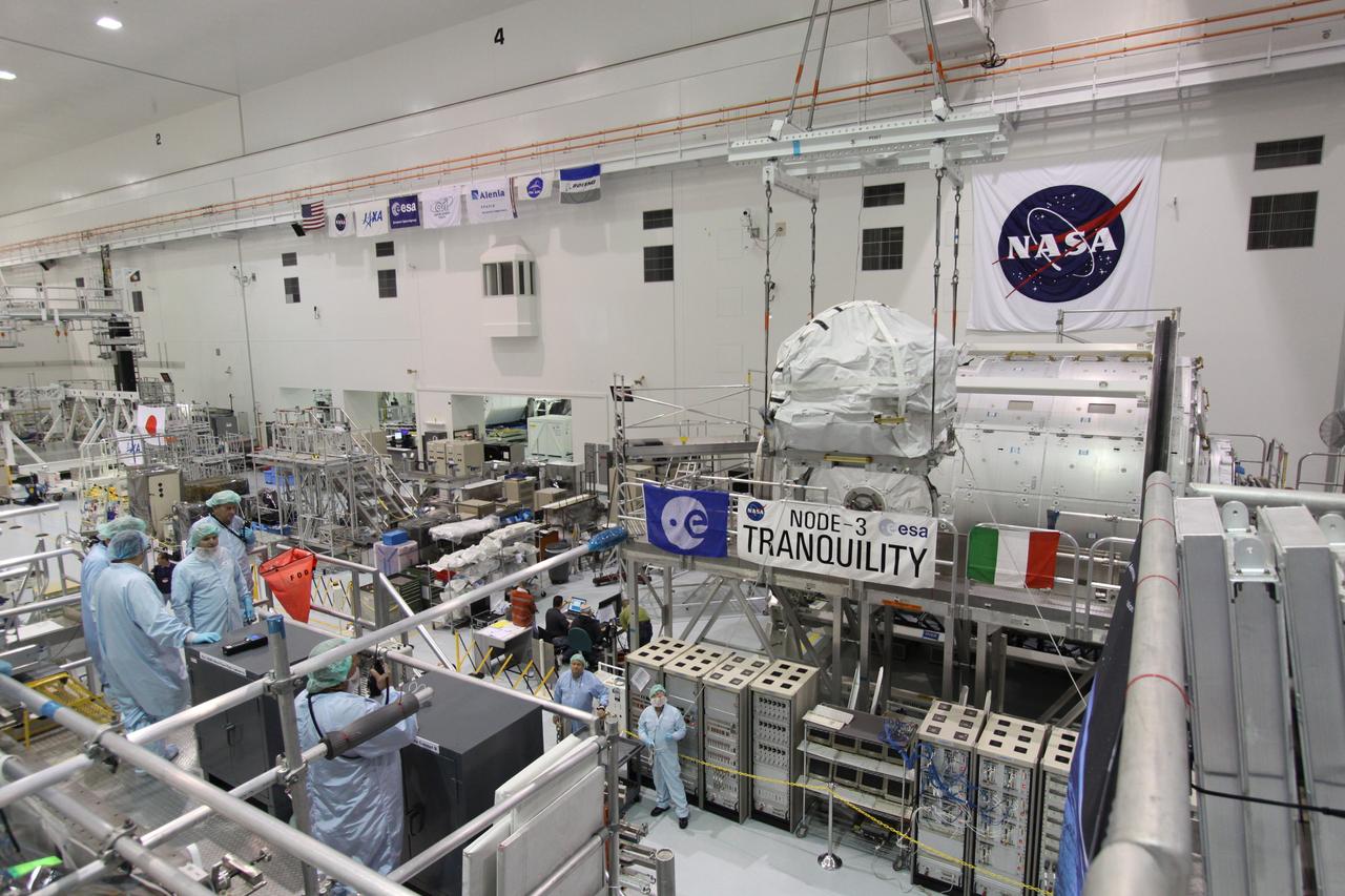 CAPE CANAVERAL, Fla. – In the Space Station Processing Facility at NASA's Kennedy Space Center in Florida,  technicians keep watch as the control moment gyroscope is lifted past the Node 3 Tranquility module to an EXPRESS Logistics Carrier.  The carrier is part of the STS-129 payload on space shuttle Atlantis, which will deliver to the International Space Station two spare gyroscopes, two nitrogen tank assemblies, two pump modules, an ammonia tank assembly and a spare latching end effector for the station's robotic arm.  STS-129 is targeted to launch Nov. 12 .  Photo credit: NASA/Jack Pfaller