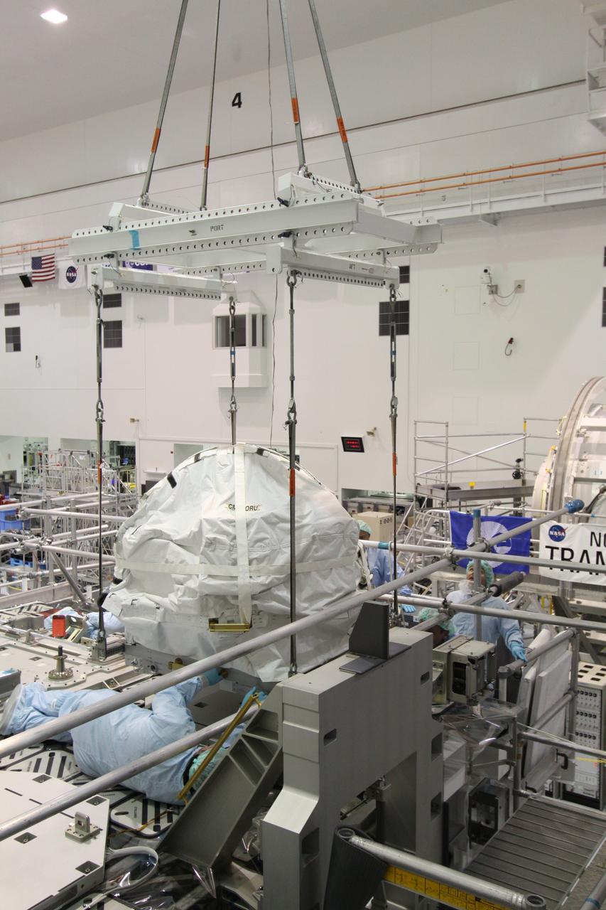 CAPE CANAVERAL, Fla. – In the Space Station Processing Facility at NASA's Kennedy Space Center in Florida,  technicians watch as the control moment gyroscope is lowered onto an EXPRESS Logistics Carrier.  The carrier is part of the STS-129 payload on space shuttle Atlantis, which will deliver to the International Space Station two spare gyroscopes, two nitrogen tank assemblies, two pump modules, an ammonia tank assembly and a spare latching end effector for the station's robotic arm.  STS-129 is targeted to launch Nov. 12 .  Photo credit: NASA/Jack Pfaller