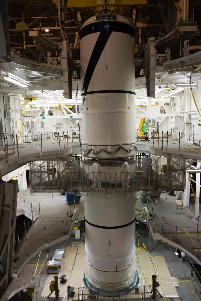 CAPE CANAVERAL, Fla. – In the High Bay 3 of NASA Kennedy Space Center's Vehicle Assembly Building, the Ares I-X forward segment is lowered onto the forward center for mating. The forward center is already mated with the aft center and the aft skirt segments below. Part of the Constellation Program, the Ares I-X is the test vehicle for the Ares I, which is the essential core of a space transportation system that eventually will carry crewed missions back to the moon, on to Mars and out into the solar system . The Ares I-X flight test is targeted for no earlier than Aug. 30. Photo credit: NASA/Troy Cryder