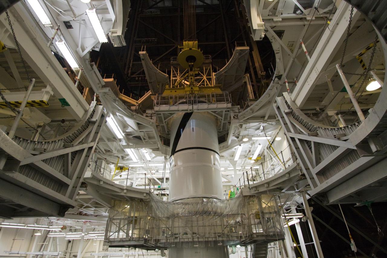CAPE CANAVERAL, Fla. – In the Vehicle Assembly Building's High Bay 3 at NASA's Kennedy Space Center in Florida, workers check the attachment, or mating, of the Ares I-X forward center segment atop the aft assembly (aft segment and aft skirt). Part of the Constellation Program, the Ares I-X is the test vehicle for the Ares I, which is the essential core of a space transportation system that eventually will carry crewed missions back to the moon, on to Mars and out into the solar system . The Ares I-X flight test is targeted for no earlier than Aug. 30. Photo credit: NASA/Jack Pfaller