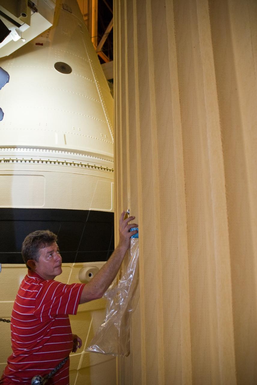 CAPE CANAVERAL, Fla. –  In the Vehicle Assembly Building's  High Bay 1 at NASA's Kennedy Space Center in Florida, Eugene Sweet, a principal liaison engineer from NASA's Michoud Assembly Facility near New Orleans where the external fuel tanks are built, is testing foam adhesion on the intertank of space shuttle Discovery's  external tank.  He is collecting foam samples an inch-and-half in diameter for analysis to confirm the foam is bonded well to the metal primer underneath. The testing was prompted by the foam loss during launch of space shuttle Endeavour on the STS-127 mission July 15. Samples are being sent to Michoud for study.  Photo credit: NASA/Tim Jacobs
