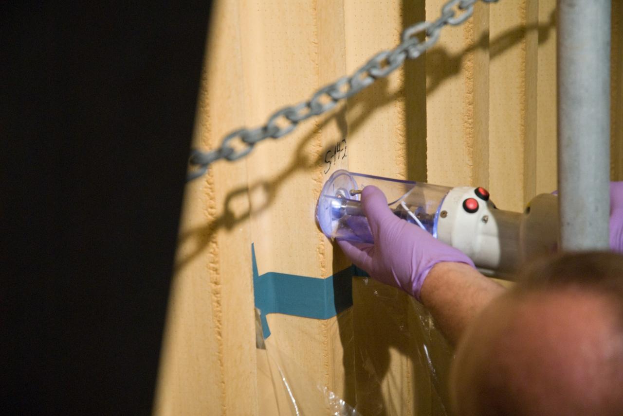 CAPE CANAVERAL, Fla. – In the Vehicle Assembly Building's  High Bay 1 at NASA's Kennedy Space Center in Florida, foam adhesion is being tested on the intertank of space shuttle Discovery's  external tank.  Foam samples an inch-and-half in diameter are being collected for analysis to confirm the foam is bonded well to the metal primer underneath. The testing was prompted by the foam loss during launch of space shuttle Endeavour on the STS-127 mission July 15. Samples are being sent to Michoud for study.  Photo credit: NASA/Tim Jacobs