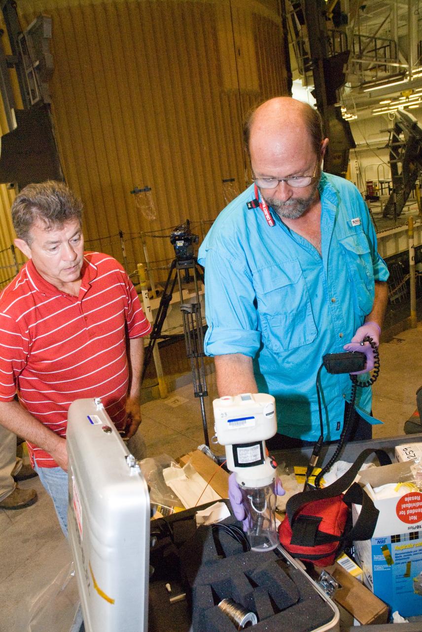 CAPE CANAVERAL, Fla. – In the Vehicle Assembly Building's High Bay 1 at NASA's Kennedy Space Center in Florida, Eugene Sweet (left), a principal liaison engineer, and David Buras, a Material and Process engineer from NASA's Michoud Assembly Facility near New Orleans where the fuel tanks are built, are testing foam samples taken from the intertank of space shuttle Discovery's  external tank.  They are collecting foam samples an inch-and-half in diameter for analysis to confirm the foam is bonded well to the metal primer underneath. The testing of foam adhesion was prompted by the foam loss during launch of space shuttle Endeavour on the STS-127 mission July 15.  Samples are being sent to Michoud for study.  Photo credit: NASA/Tim Jacobs