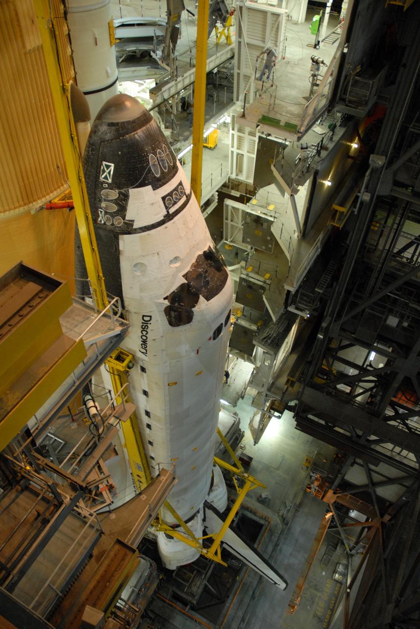 CAPE CANAVERAL, Fla. – In High Bay 1 of the Vehicle Assembly Building at NASA's Kennedy Space Center in Florida, space shuttle Discovery is lowered onto the mobile launcher platform, or MLP.  It is in front of the external fuel tank and solid rocket boosters on either side.  The shuttle will be attached to the external tank on the MLP. Discovery is scheduled to roll out to Launch Pad 39A the first week of August to prepare for the STS-128 mission to the International Space Station.  The shuttle will carry the Leonardo Multi-Purpose Logistics Module containing life support racks and science racks and the Lightweight Multi-Purpose Experiment Support Structure Carrier in its payload bay.  Launch of Discovery is targeted for late August.  Photo credit: NASA/Ben Smegelsky