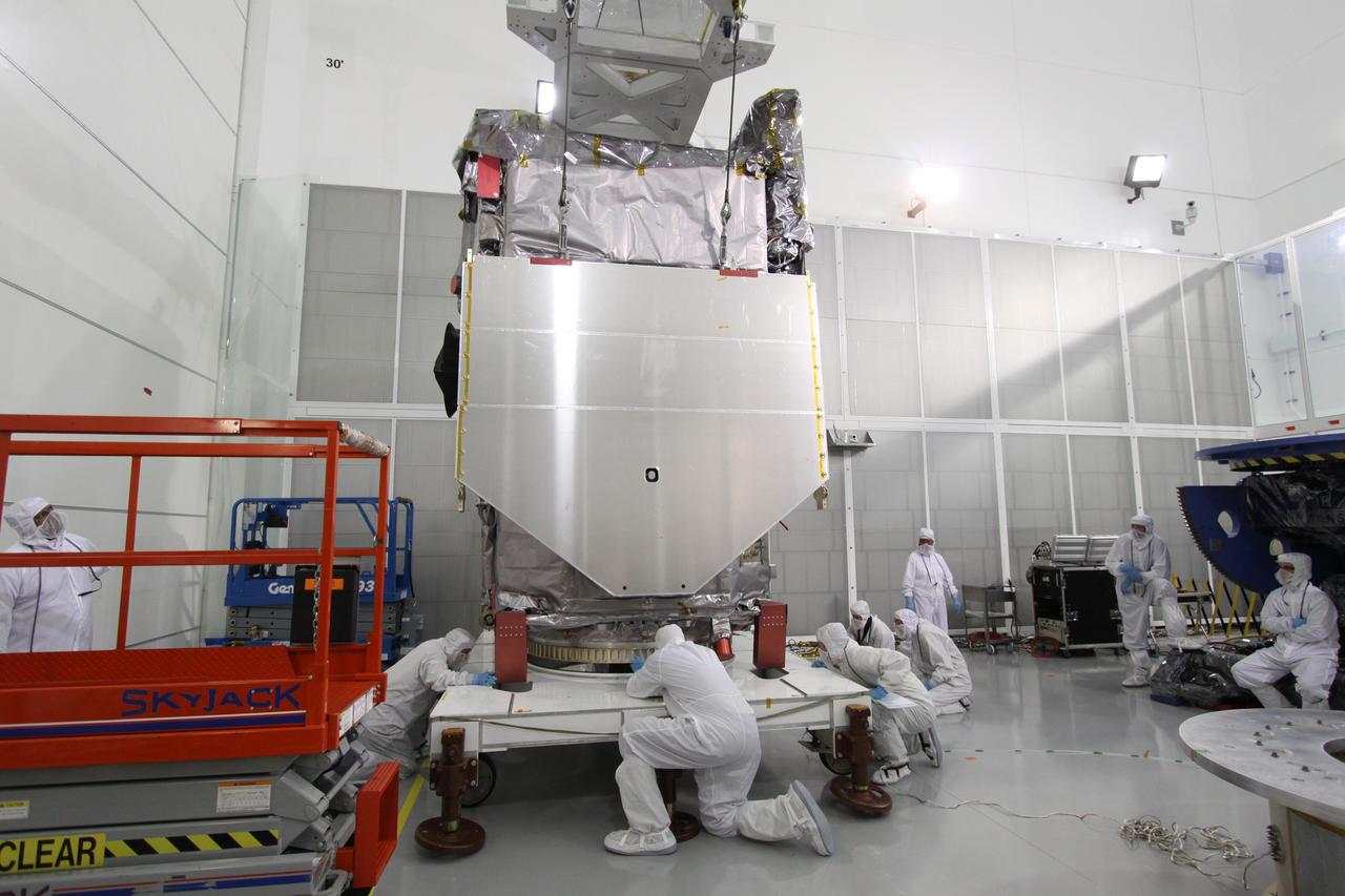 CAPE CANAVERAL, Fla. – At the Astrotech Payload Processing Facility in Titusville, Fla., technicians check the clearance as the Solar Dynamics Observatory is lifted from the stand.  The spacecraft is being moved onto a Ransome table that will allow it to be rotated in various directions for access to different areas of the spacecraft.  SDO is the first space weather research network mission in NASA's Living With a Star Program.  The spacecraft's long-term measurements will give solar scientists in-depth information about changes in the sun's magnetic field and insight into how they affect Earth.  In preparation for its anticipated November launch, engineers will perform a battery of comprehensive tests to ensure SDO can withstand the stresses and vibrations of the launch itself, as well as what it will encounter in the space environment after launch.  Photo credit: NASA/Jack Pfaller