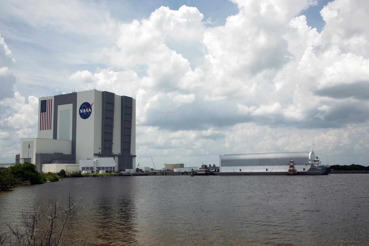 CAPE CANAVERAL, Fla. – Tugboats maneuver NASA's Pegasus barge toward the Turn Basin dock at NASA's Kennedy Space Center in Florida. The barge contains the external fuel tank, designated ET-133, that will be used for space shuttle Atlantis' STS-129 mission.  After Pegasus is docked, the tank will be offloaded and moved into a high bay in the Vehicle Assembly Building, at left, for checkout.  The tank was shipped aboard the Pegasus from NASA's Michould Assembly Facility near New Orleans. Pegasus was towed to Port Canaveral by the Freedom Star Retrieval Ship.  Photo credit: NASA/Dimitri Gerondidakis