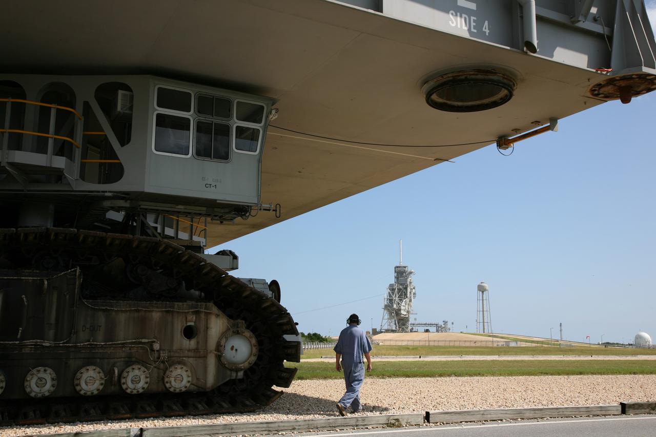 CAPE CANAVERAL, Fla. – At NASA's Kennedy Space Center in Florida, a worker walks alongside the crawler-transporter as it carries space shuttle Endeavour to Launch Pad 39A. The 3.4-mile journey was slower than usual as technicians stopped several times to clear mud from the crawler's treads and bearings caused by the waterlogged crawlerway. First motion out of the Vehicle Assembly Building was at 2:07 a.m. EDT Aug. 4. Rollout was delayed approximately 2 hours due to lightning in the area. Discovery's 13-day flight will deliver a new crew member and 33,000 pounds of equipment to the International Space Station. The equipment includes science and storage racks, a freezer to store research samples, a new sleeping compartment and the COLBERT treadmill. Launch of Discovery on its STS-128 mission is targeted for late August. Photo credit: NASA/Dimitri Gerondidakis