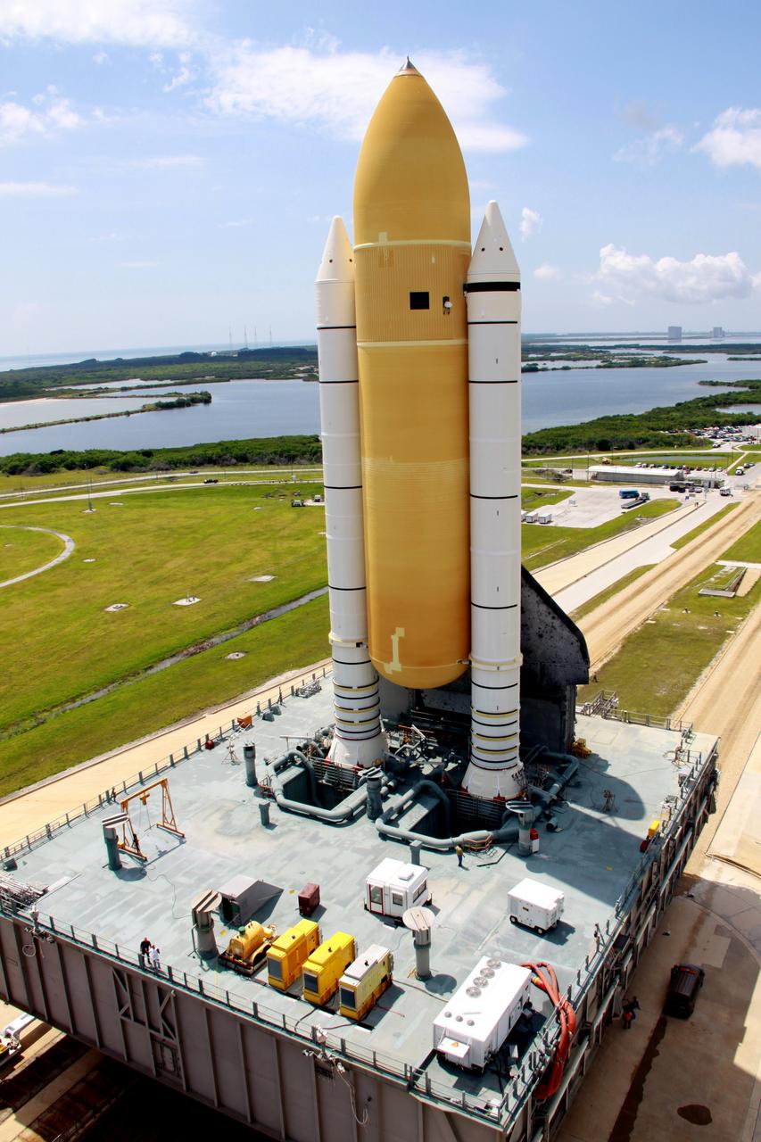 CAPE CANAVERAL, Fla. – Sitting on top of the mobile launcher platform, space shuttle Discovery arrives on top of Launch Pad 39A at NASA's Kennedy Space Center in Florida. Traveling from the Vehicle Assembly Building, the shuttle took nearly 12 hours on the journey as technicians stopped several times to clear mud from the crawler's treads and bearings caused by the waterlogged crawlerway. First motion out of the VAB was at 2:07 a.m. EDT Aug. 4. Rollout was delayed approximately 2 hours due to lightning in the area. Discovery's 13-day flight will deliver a new crew member and 33,000 pounds of equipment to the International Space Station. The equipment includes science and storage racks, a freezer to store research samples, a new sleeping compartment and the COLBERT treadmill. Launch of Discovery on its STS-128 mission is targeted for late August. Photo credit: NASA/Troy Cryder