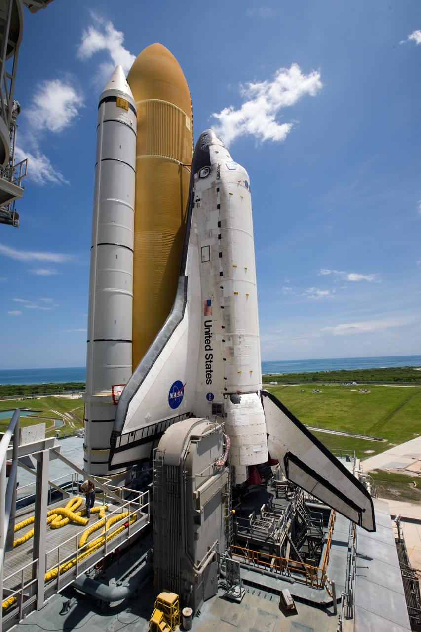 CAPE CANAVERAL, Fla. – Sitting on top of the mobile launcher platform, space shuttle Discovery arrives on top of Launch Pad 39A at NASA's Kennedy Space Center in Florida. Traveling from the Vehicle Assembly Building, the shuttle took nearly 12 hours on the journey as technicians stopped several times to clear mud from the crawler's treads and bearings caused by the waterlogged crawlerway. First motion out of the VAB was at 2:07 a.m. EDT Aug. 4. Rollout was delayed approximately 2 hours due to lightning in the area. In the foreground next to Discovery's main engines is one of the two tail masts, which provide several umbilical connections to the orbiter, including a liquid-oxygen line through one and a liquid-hydrogen line through another. Discovery's 13-day flight will deliver a new crew member and 33,000 pounds of equipment to the International Space Station. The equipment includes science and storage racks, a freezer to store research samples, a new sleeping compartment and the COLBERT treadmill. Launch of Discovery on its STS-128 mission is targeted for late August. Photo credit: NASA/Troy Cryder