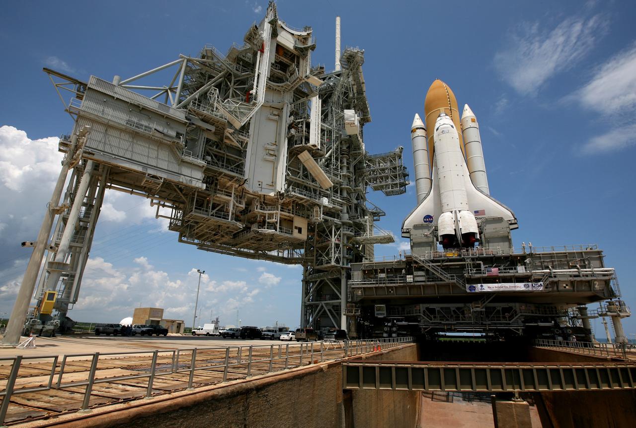 CAPE CANAVERAL, Fla. – Sitting on top of the mobile launcher platform, space shuttle Discovery straddles the flame trench, which channels the flames and smoke exhaust of the shuttle's solid rocket boosters away from the space shuttle during liftoff, on Launch Pad 39A at NASA's Kennedy Space Center in Florida. Traveling from the Vehicle Assembly Building, the shuttle took nearly 12 hours on the journey as technicians stopped several times to clear mud from the crawler's treads and bearings caused by the waterlogged crawlerway.  First motion out of the VAB was at 2:07 a.m. EDT Aug. 4. Rollout was delayed approximately 2 hours due to lightning in the area. Discovery was secured, or "hard down" to Launch Pad 39A at 1:50 p.m. EDT. "Hard down" means that the mobile launcher platform, or MLP, is sitting on the pedestals on the pad, and the crawler has been jacked down, thus transferring the weight of the MLP from the crawler to the pad pedestals.  Discovery's 13-day flight will deliver a new crew member and 33,000 pounds of equipment to the International Space Station. The equipment includes science and storage racks, a freezer to store research samples, a new sleeping compartment and the COLBERT treadmill.  Launch of Discovery on its STS-128 mission is targeted for late August.   Photo credit: NASA/Troy Cryder