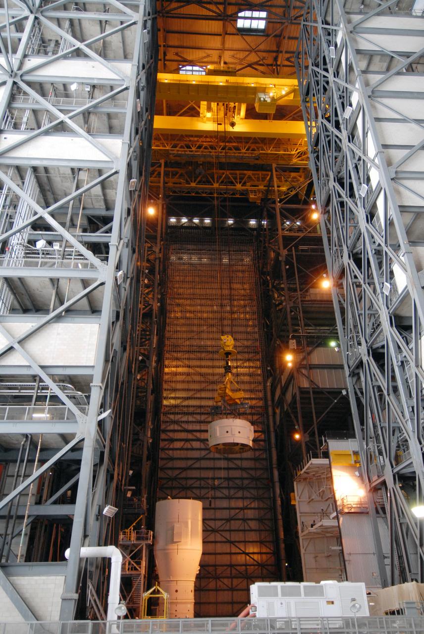 CAPE CANAVERAL, Fla. – In the Vehicle Assembly Building's High Bay 3 at NASA's Kennedy Space Center in Florida, a crane lowers Super Stack 2, part of the Ares I-X upper stage, for integration with Super Stack 1. The upper stage comprises five super stacks, which are integrated with the four-segment solid rocket booster first stage on the mobile launch platform. Ares I-X is the test vehicle for the Ares I, which is part of the Constellation Program to return men to the moon and beyond. The Ares I-X flight test is targeted for Oct. 31, pending formal NASA Headquarters approval. Photo credit: NASA/Tim Jacobs