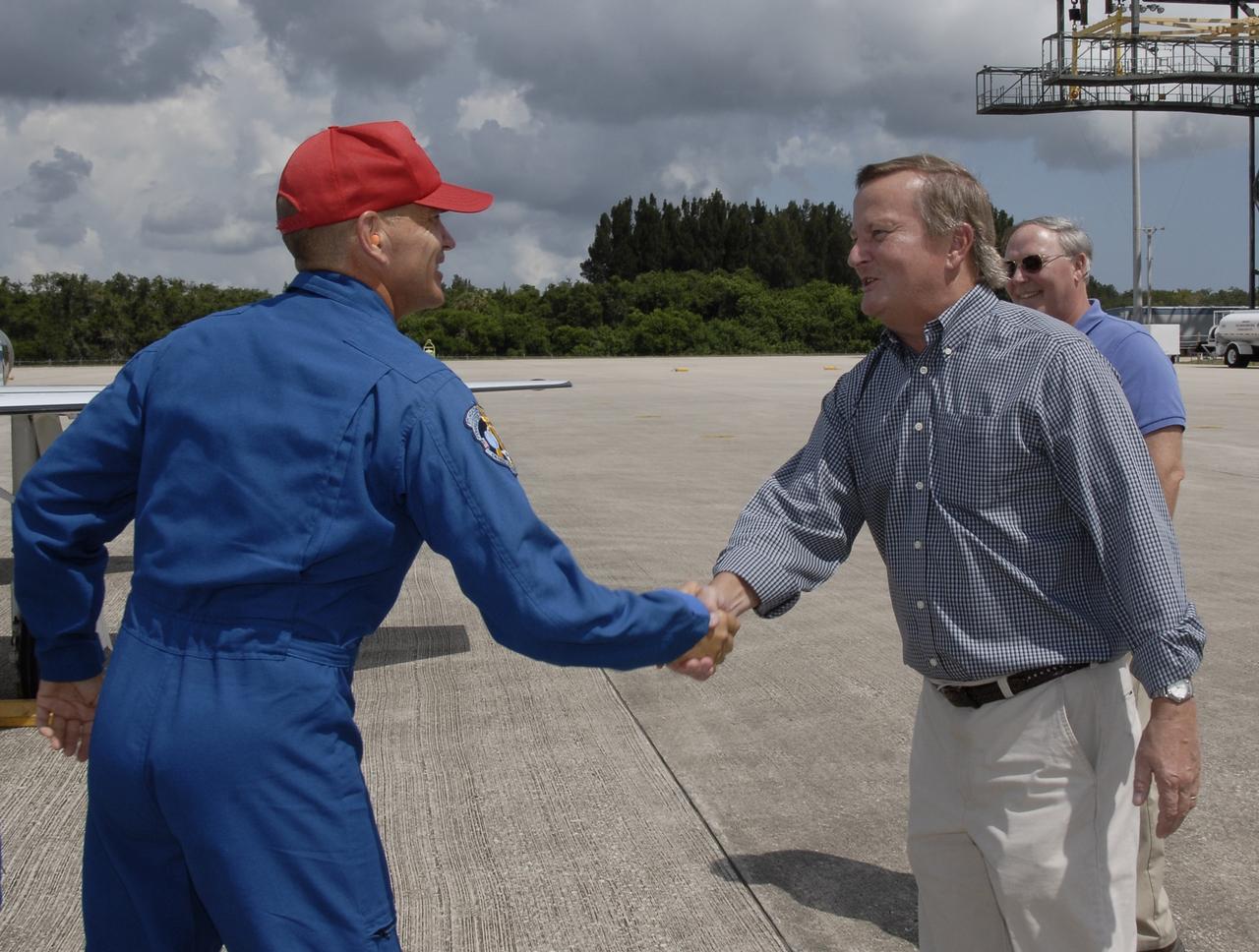 CAPE CANAVERAL, Fla. – Space shuttle Discovery's STS-128 mission crew members arrive in T-38 training jets at NASA Kennedy Space Center's Shuttle Landing Facility.  Commander Rick Sturckow is greeted by Shuttle Launch Director Mike Leinbach. Behind Leinbach is Chief of the Vehicle Integration Test Office Jerry Ross.  The astronauts will be taking part in terminal countdown demonstration test activities that include equipment familiarization and emergency egress training, and will culminate in a simulated launch countdown aboard Discovery.  The mission will deliver a new crew member and 33,000 pounds of equipment to the International Space Station. The equipment includes science and storage racks, a freezer to store research samples, a new sleeping compartment and the COLBERT treadmill.  Launch of Discovery is targeted for late August. Photo credit: NASA/Kim Shiflett