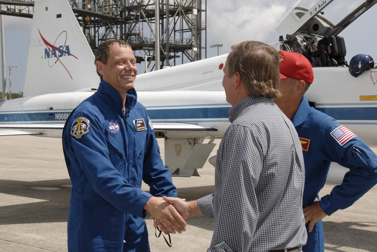 CAPE CANAVERAL, Fla. – Space shuttle Discovery's STS-128 mission crew members arrive in T-38 training jets at NASA Kennedy Space Center's Shuttle Landing Facility.  Seen here is Mission Specialist Christer Fuglesang, who represents the European Space Agency, being greeted by Shuttle Launch Director Mike Leinbach.  At right is Commander Rick Sturckow. The astronauts will be taking part in terminal countdown demonstration test activities that include equipment familiarization and emergency egress training, and will culminate in a simulated launch countdown aboard Discovery.  The mission will deliver a new crew member and 33,000 pounds of equipment to the International Space Station. The equipment includes science and storage racks, a freezer to store research samples, a new sleeping compartment and the COLBERT treadmill.  Launch of Discovery is targeted for late August. Photo credit: NASA/Kim Shiflett