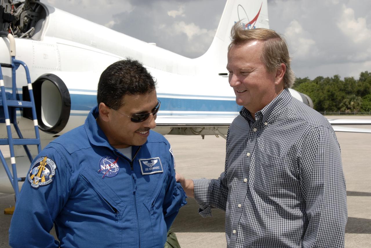 CAPE CANAVERAL, Fla. – Space shuttle Discovery's STS-128 mission crew members arrive in T-38 training jets at NASA Kennedy Space Center's Shuttle Landing Facility.  Mission Specialist Jose Hernandez is greeted by Shuttle Launch Director Mike Leinbach. The astronauts will be taking part in terminal countdown demonstration test activities that include equipment familiarization and emergency egress training, and will culminate in a simulated launch countdown aboard Discovery.  The mission will deliver a new crew member and 33,000 pounds of equipment to the International Space Station. The equipment includes science and storage racks, a freezer to store research samples, a new sleeping compartment and the COLBERT treadmill.  Launch of Discovery is targeted for late August. Photo credit: NASA/Kim Shiflett