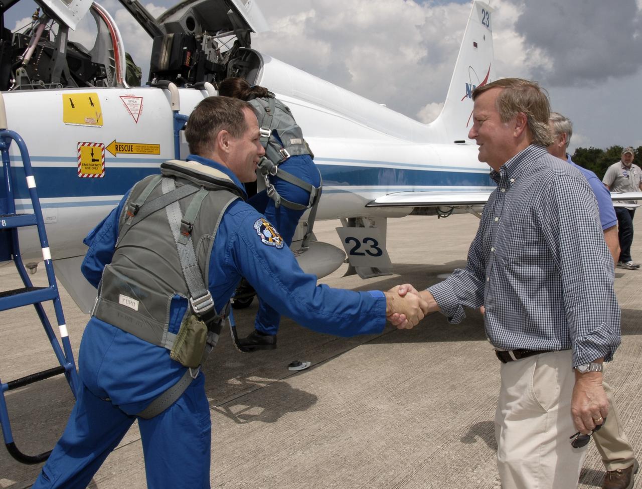 CAPE CANAVERAL, Fla. – Space shuttle Discovery's STS-128 mission crew members arrive in T-38 training jets at NASA Kennedy Space Center's Shuttle Landing Facility. Here, Pilot Kevin Ford is greeted by Shuttle Launch Director Mike Leinbach. The astronauts will be taking part in terminal countdown demonstration test activities that include equipment familiarization and emergency egress training, and will culminate in a simulated launch countdown aboard Discovery. The mission will deliver a new crew member and 33,000 pounds of equipment to the International Space Station. The equipment includes science and storage racks, a freezer to store research samples, a new sleeping compartment and the COLBERT treadmill. Launch of Discovery is targeted for late August. Photo credit: NASA/Kim Shiflett