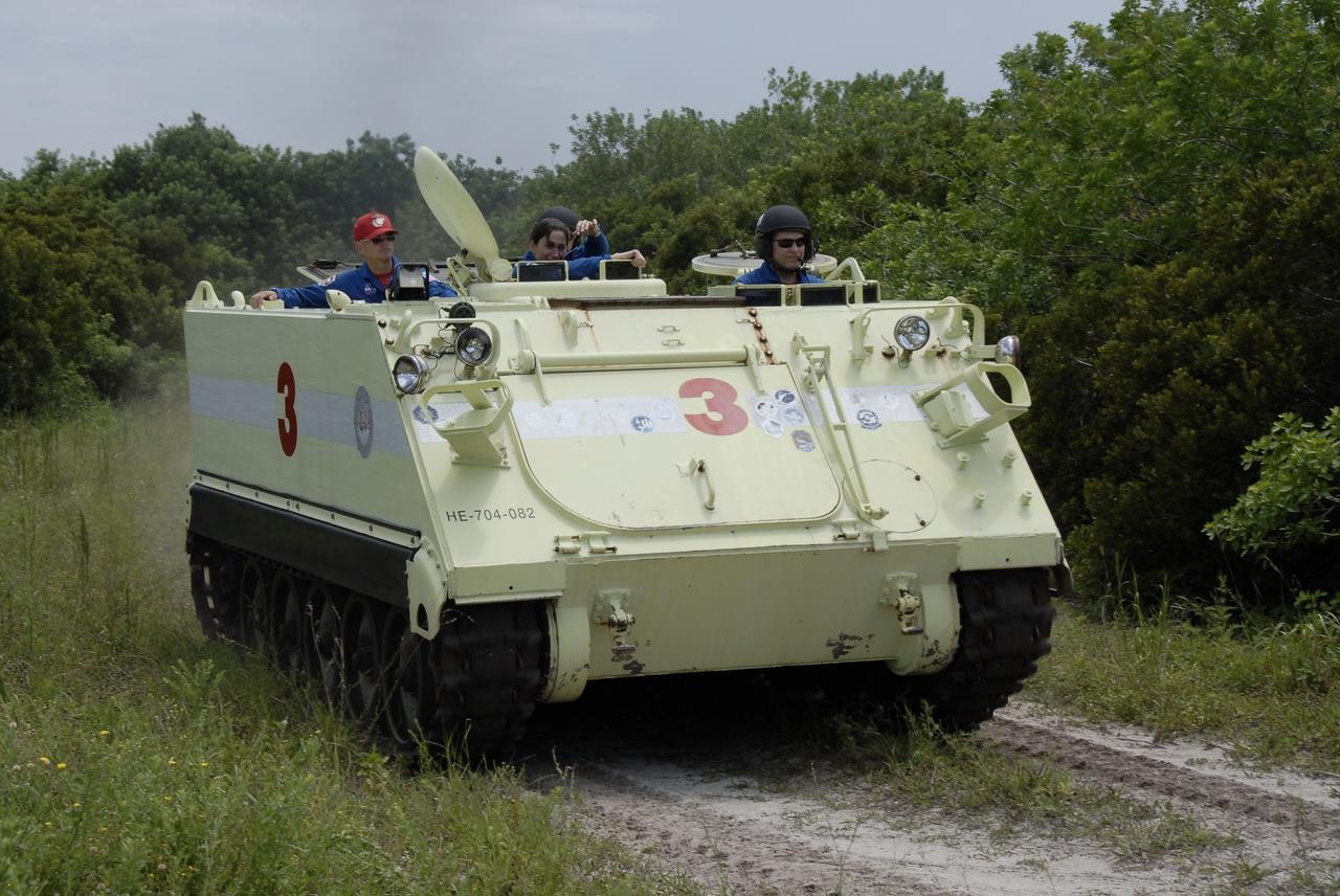 CAPE CANAVERAL, Fla. – At NASA's Kennedy Space Center in Florida, STS-128 Pilot Kevin Ford drives an M-113 armored personnel carrier.  At far left is Commander Rick Sturckow. Other crew members will take their turns at driving the M-113. The crew members of space shuttle Discovery's STS-128 mission are taking turns driving the M-113, which will be available to transport the crew to safety in the event of a contingency on the pad before their launch. The crew is at Kennedy for a launch dress rehearsal called the terminal countdown demonstration test, or TCDT, which includes emergency exit training and equipment familiarization, as well as a simulated launch countdown.  Launch of le Discovery is targeted for late August. Photo credit: NASA/Kim Shiflett