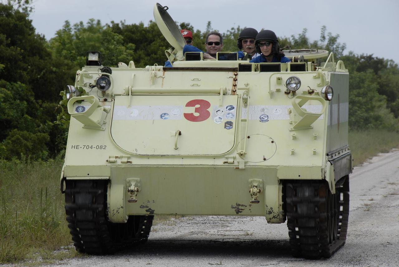 CAPE CANAVERAL, Fla. – At NASA's Kennedy Space Center in Florida, STS-128 Mission Specialist Nicole Stott drives an M-113 armored personnel carrier. Behind Stott are (from left) Commander Rick Sturckow and Pilot Kevin Ford, who already took their turns at driving the M-113. The crew is at Kennedy for a launch dress rehearsal called the terminal countdown demonstration test, or TCDT, which includes emergency exit training and equipment familiarization, as well as a simulated launch countdown.  Launch of Discovery is targeted for late August. Photo credit: NASA/Kim Shiflett