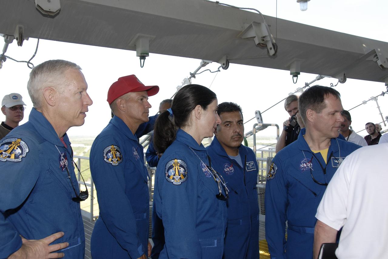 CAPE CANAVERAL, Fla. –  At NASA's Kennedy Space Center in Florida, STS-128 crew members get instructions about using slidewire baskets for emergency exit from the fixed service structure on Launch Pad 39A.  From left are Mission Specialist Patrick Forrester, Commander Rick Sturckow, Mission Specialists Nicole Stott and Jose Hernandez, and Pilot Kevin Ford.  The crew is at Kennedy for a launch dress rehearsal called the terminal countdown demonstration test, or TCDT, which includes emergency exit training and equipment familiarization, as well as a simulated launch countdown.  Discovery will deliver 33,000 pounds of equipment to the station, including science and storage racks, a freezer to store research samples, a new sleeping compartment and the COLBERT treadmill. Photo credit: NASA/Kim Shiflett