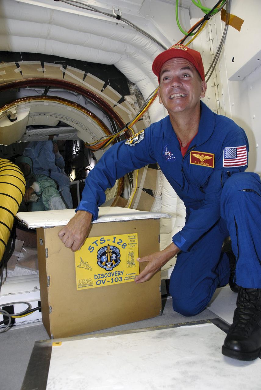CAPE CANAVERAL, Fla. – Inside the White Room on Launch Pad 39A at NASA's Kennedy Space Center in Florida, STS-128 Commander Rick Sturckow places a mission patch on part of the hatch for space shuttle Discovery. The crew is at Kennedy for a launch dress rehearsal called the terminal countdown demonstration test, or TCDT, which includes emergency exit training and equipment familiarization, as well as a simulated launch countdown. Discovery will deliver 33,000 pounds of equipment to the station, including science and storage racks, a freezer to store research samples, a new sleeping compartment and the COLBERT treadmill. Photo credit: NASA/Kim Shiflett