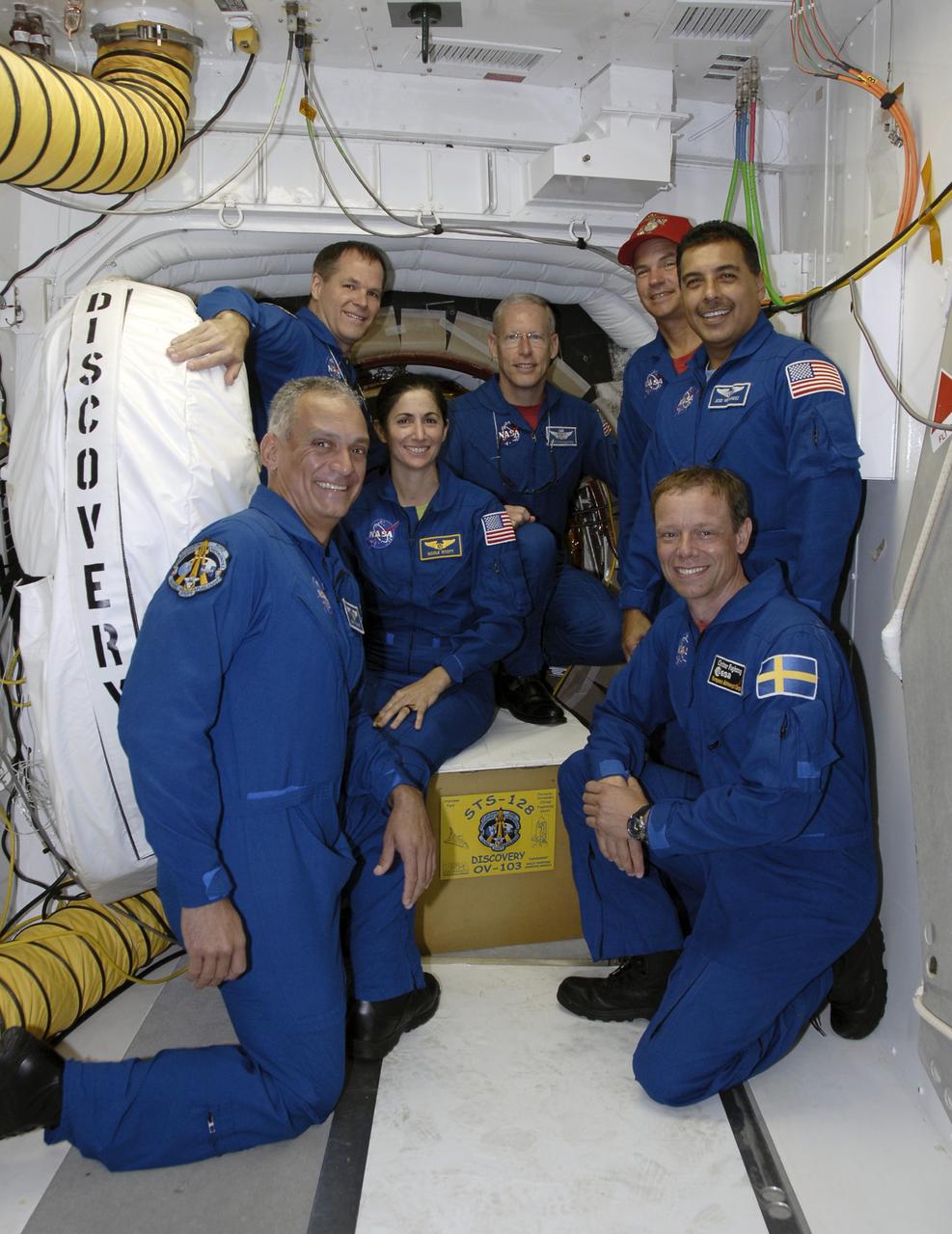 CAPE CANAVERAL, Fla. – Inside the White Room on Launch Pad 39A at NASA's Kennedy Space Center in Florida, STS-128 crew members pose in front of the space shuttle Discovery's hatch.  Clockwise from lower left are Mission Specialist John "Danny" Olivas, Pilot Kevin Ford, Mission Specialists Nicole Stott and Patrick Forrester, Commander Rick Sturckow, and Mission Specialists Jose Hernandez and Christer Fuglesang, who represents the European Space Agency. The crew is at Kennedy for a launch dress rehearsal called the terminal countdown demonstration test, or TCDT, which includes emergency exit training and equipment familiarization, as well as a simulated launch countdown.  Discovery will deliver 33,000 pounds of equipment to the station, including science and storage racks, a freezer to store research samples, a new sleeping compartment and the COLBERT treadmill. Photo credit: NASA/Kim Shiflett