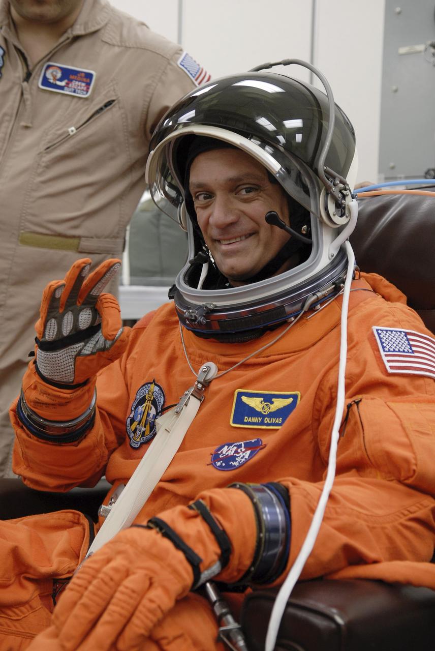 CAPE CANAVERAL, Fla. – STS-128 Mission Specialist Danny Olivas signals the fit of his launch and entry suit and helmet before heading to the NASA Kennedy Space Center's Launch Pad 39A for the simulated launch countdown. The countdown is the culmination of terminal countdown demonstration test activities to prepare the STS-128 crew for launch on space shuttle Discovery's STS-128 mission. Discovery will deliver 33,000 pounds of equipment to the station, including science and storage racks, a freezer to store research samples, a new sleeping compartment and the COLBERT treadmill. Launch is targeted for late August. Photo credit: NASA/Kim Shiflett