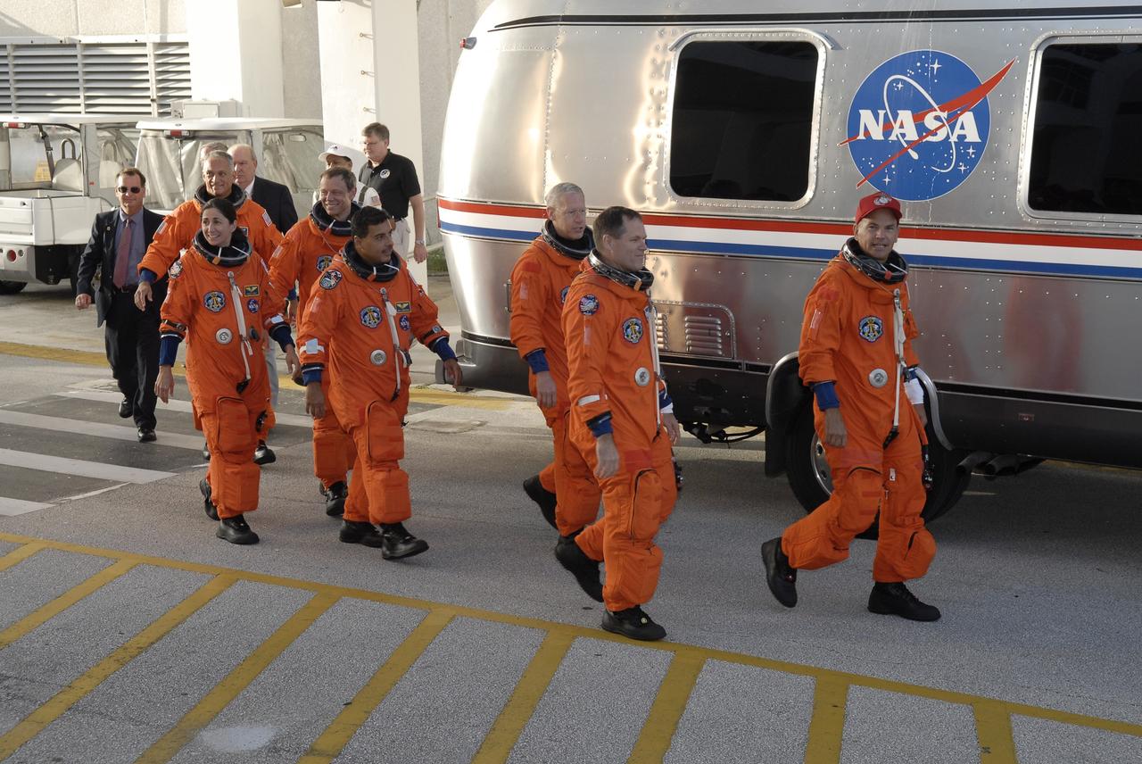 CAPE CANAVERAL, Fla. –  The suited STS-128 crew members head for the Astrovan to take them to NASA Kennedy Space Center's Launch Pad 39A and a simulated launch countdown.  From left are Mission Specialists Danny Olivas, Nicole Stott, Christer Fuglesang, Jose Hernandez and Patrick Forrester, Pilot Kevin Ford and Commander Rick Sturckow. The countdown is the culmination of terminal countdown demonstration test activities to prepare the STS-128 crew for launch on space shuttle Discovery's STS-128 mission. Discovery will deliver 33,000 pounds of equipment to the station, including science and storage racks, a freezer to store research samples, a new sleeping compartment and the COLBERT treadmill.  Launch is targeted for late August. Photo credit: NASA/Kim Shiflett