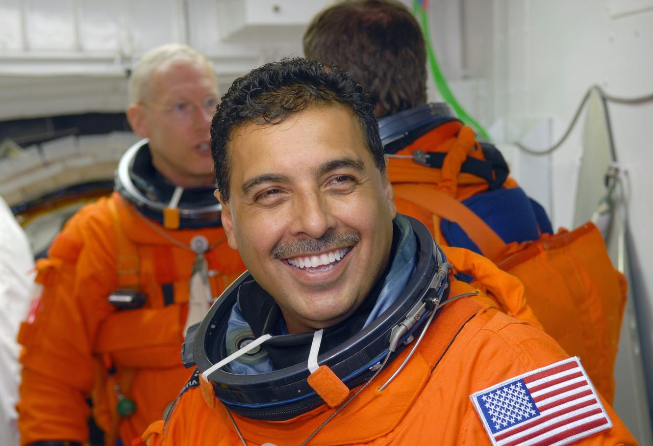 CAPE CANAVERAL, Fla. – In the White Room on NASA Kennedy Space Center's Launch Pad 39A, STS-128 Mission Specialist Jose Hernandez waits his turn to enter space shuttle Discovery.  In the background are Mission Specialists Patrick Forrester (left) and Christer Fuglesang (back to camera). The White Room is at the end of the orbiter access arm and provides entry into the shuttle. Mission crew members are at Kennedy to take part in the terminal countdown demonstration test, or TCDT, which culminates in a simulated launch countdown inside the shuttle.  On the STS-128 mission, Discovery will deliver 33,000 pounds of equipment to the station, including science and storage racks, a freezer to store research samples, a new sleeping compartment and the COLBERT treadmill.  Launch is targeted for late August.  Photo credit: NASA/Jim Grossmann