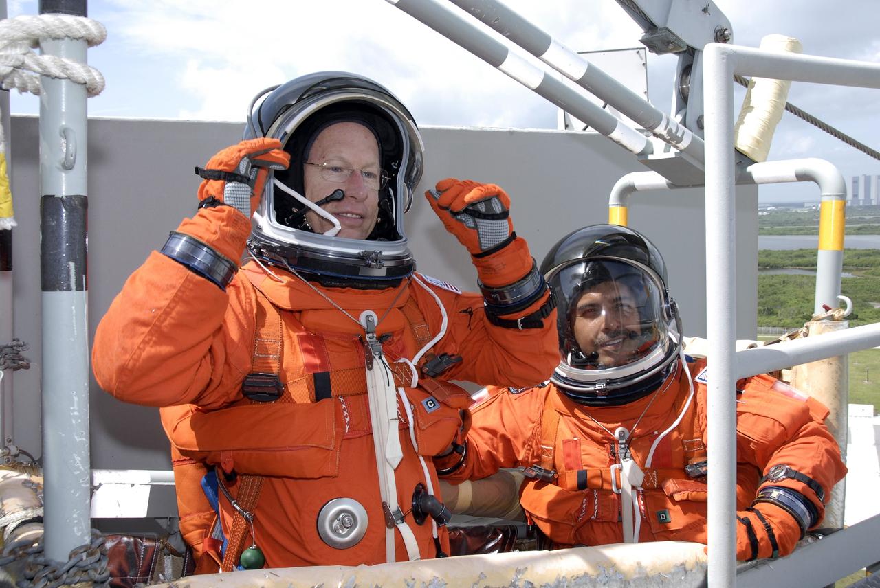 CAPE CANAVERAL, Fla. – After a successful simulated launch countdown, STS-128 Mission Specialists Patrick Forrester (left) and Jose Hernandez relax in the slidewire basket on NASA Kennedy Space Center's fixed service structure.  They have completed practicing emergency exit from the pad.  Mission crew members are at Kennedy to take part in the terminal countdown demonstration test, or TCDT, which includes emergency exit training and culminates in the simulated countdown. On the STS-128 mission, Discovery will deliver 33,000 pounds of equipment to the station, including science and storage racks, a freezer to store research samples, a new sleeping compartment and the COLBERT treadmill.  Launch is targeted for late August.   Photo credit: NASA/Kim Shiflett