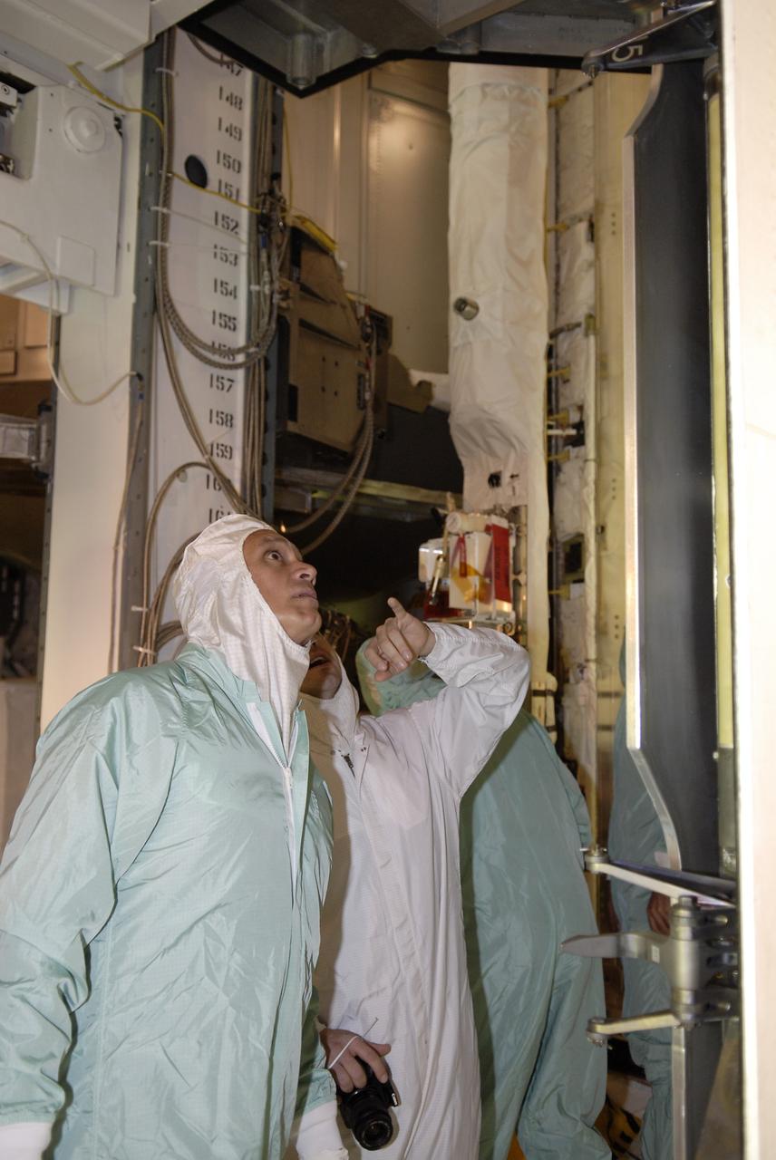 CAPE CANAVERAL, Fla. – – In the Payload Changeout Room on NASA Kennedy Space Center's Launch Pad 39A, STS-128 crew members take a close look at the payloads to be installed in space shuttle Discovery. Seen here are Mission Specialist Danny Olivas and Pilot Kevin Ford (behind him). The crew is at Kennedy to take part in the terminal countdown demonstration test, or TCDT, which includes equipment familiarization, emergency exit training and a simulated countdown. On the STS-128 mission, Discovery will deliver 33,000 pounds of equipment to the station, including science and storage racks, a freezer to store research samples, a new sleeping compartment and the COLBERT treadmill. Launch is targeted for late August. Photo credit: NASA/Kim Shiflett