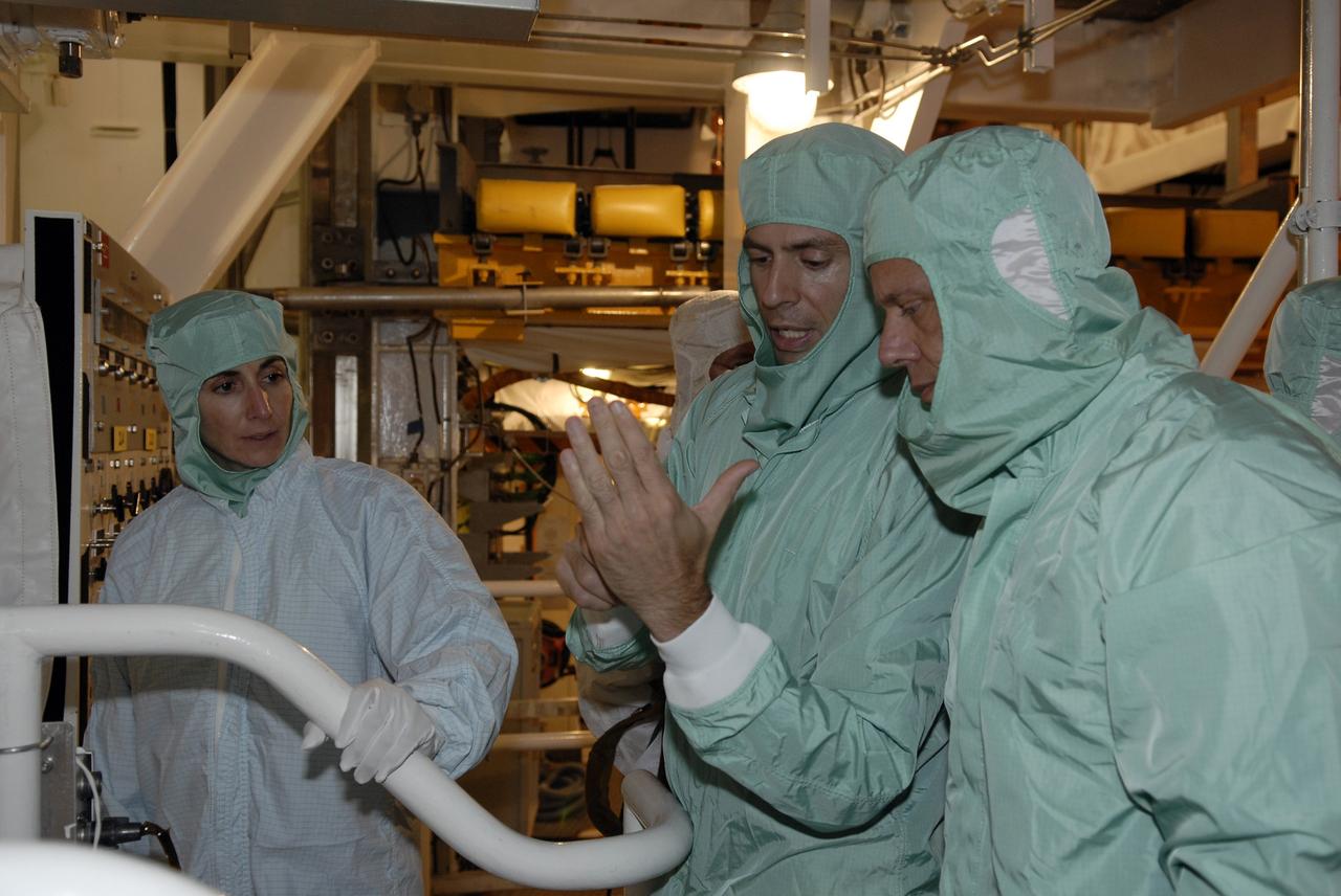 CAPE CANAVERAL, Fla. – In the Payload Changeout Room on NASA Kennedy Space Center's Launch Pad 39A, STS-128 crew members take a close look at the payloads to be installed in space shuttle Discovery. Seen here are Mission Specialists Nicole Stott (left) and Christer Fuglesang (right). The crew is at Kennedy to take part in the terminal countdown demonstration test, or TCDT, which includes equipment familiarization, emergency exit training and a simulated countdown. On the STS-128 mission, Discovery will deliver 33,000 pounds of equipment to the station, including science and storage racks, a freezer to store research samples, a new sleeping compartment and the COLBERT treadmill. Launch is targeted for late August. Photo credit: NASA/Kim Shiflett