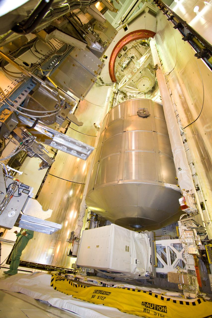 CAPE CANAVERAL, Fla. – On Launch Pad 39A, the payload ground-handling mechanism moves back after placing the multi-purpose logistics module Leonardo in space shuttle Discovery's payload bay. Leonardo is the primary payload on Discovery's STS-128 mission to the International Space Station. Beneath the module is the Lightweight Multi-Purpose Experiment Support Structure Carrier. Discovery will deliver 33,000 pounds of equipment to the station, including science and storage racks, a freezer to store research samples, a new sleeping compartment and the COLBERT treadmill. Launch is targeted for late August. Photo credit: NASA/Jack Pfaller