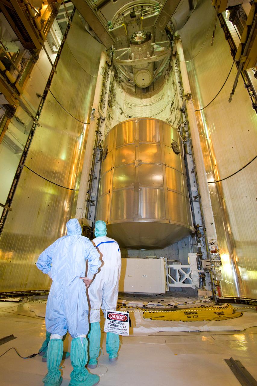 CAPE CANAVERAL, Fla. – On Launch Pad 39A, technicians observe as space shuttle Discovery's payload bay doors begin closing. Seen in the payload bay are the multi-purpose logistics module Leonardo and the lightweight multi-purpose experiment support structure carrier. Discovery will deliver 33,000 pounds of equipment to the station, including science and storage racks, a freezer to store research samples, a new sleeping compartment and the COLBERT treadmill. Launch is targeted for late August. Photo credit: NASA/Jack Pfaller
