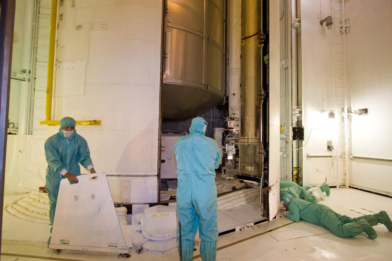 CAPE CANAVERAL, Fla. – On Launch Pad 39A, technicians check the clearance of the payload bay door as it closes around the multi-purpose logistics module Leonardo and the lightweight multi-purpose experiment support structure carrier inside space shuttle Discovery's payload bay. Discovery will deliver 33,000 pounds of equipment to the station, including science and storage racks, a freezer to store research samples, a new sleeping compartment and the COLBERT treadmill. Launch is targeted for late August. Photo credit: NASA/Jack Pfaller