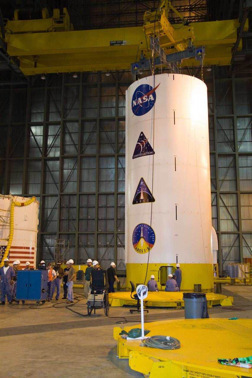 CAPE CANAVERAL, Fla. – In NASA Kennedy Space Center's Vehicle Assembly Building, a crane is attached to the Ares I-X Super Stack 3 in High Bay 3.  The stack is being moved to High Bay 4 for integration with Super Stack 2.  The upper stage comprises five super stacks, which are integrated with the four-segment solid rocket booster first stage on the mobile launch platform.  Ares I-X is the test vehicle for the Ares I, which is part of the Constellation Program to return men to the moon and beyond. The Ares I-X flight test is targeted for  Oct. 31, pending formal NASA Headquarters approval.  Photo credit: NASA/Jack Pfaller