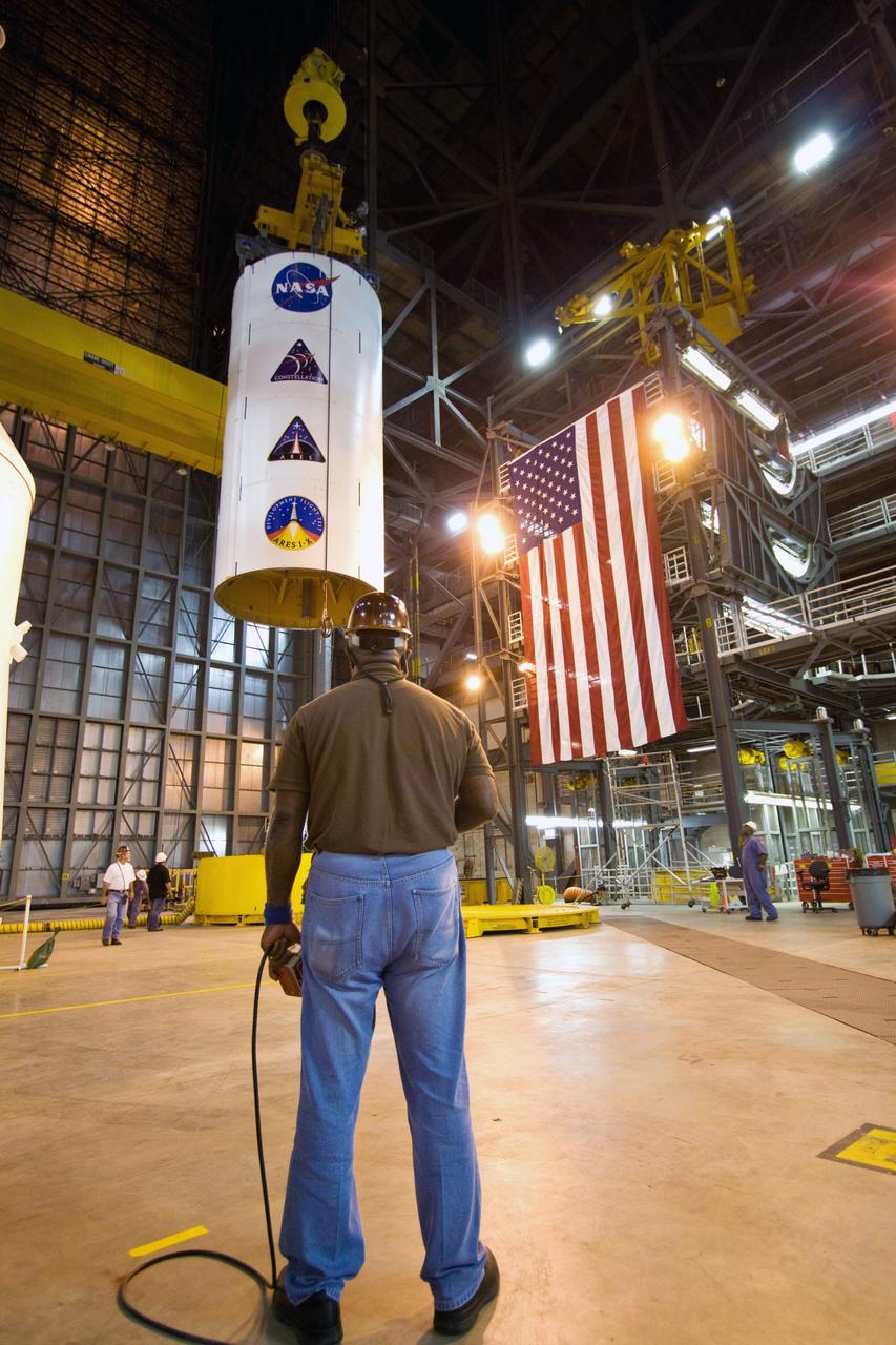 CAPE CANAVERAL, Fla. – In NASA Kennedy Space Center's Vehicle Assembly Building High Bay 3, a crane lifts the Ares I-X Super Stack 3 to move it across the transfer aisle to High Bay 4. There it will be integrated with Super Stack 2. The upper stage comprises five super stacks, which are integrated with the four-segment solid rocket booster first stage on the mobile launch platform. Ares I-X is the test vehicle for the Ares I, which is part of the Constellation Program to return men to the moon and beyond. The Ares I-X flight test is targeted for Oct. 31, pending formal NASA Headquarters approval. Photo credit: NASA/Jack Pfaller