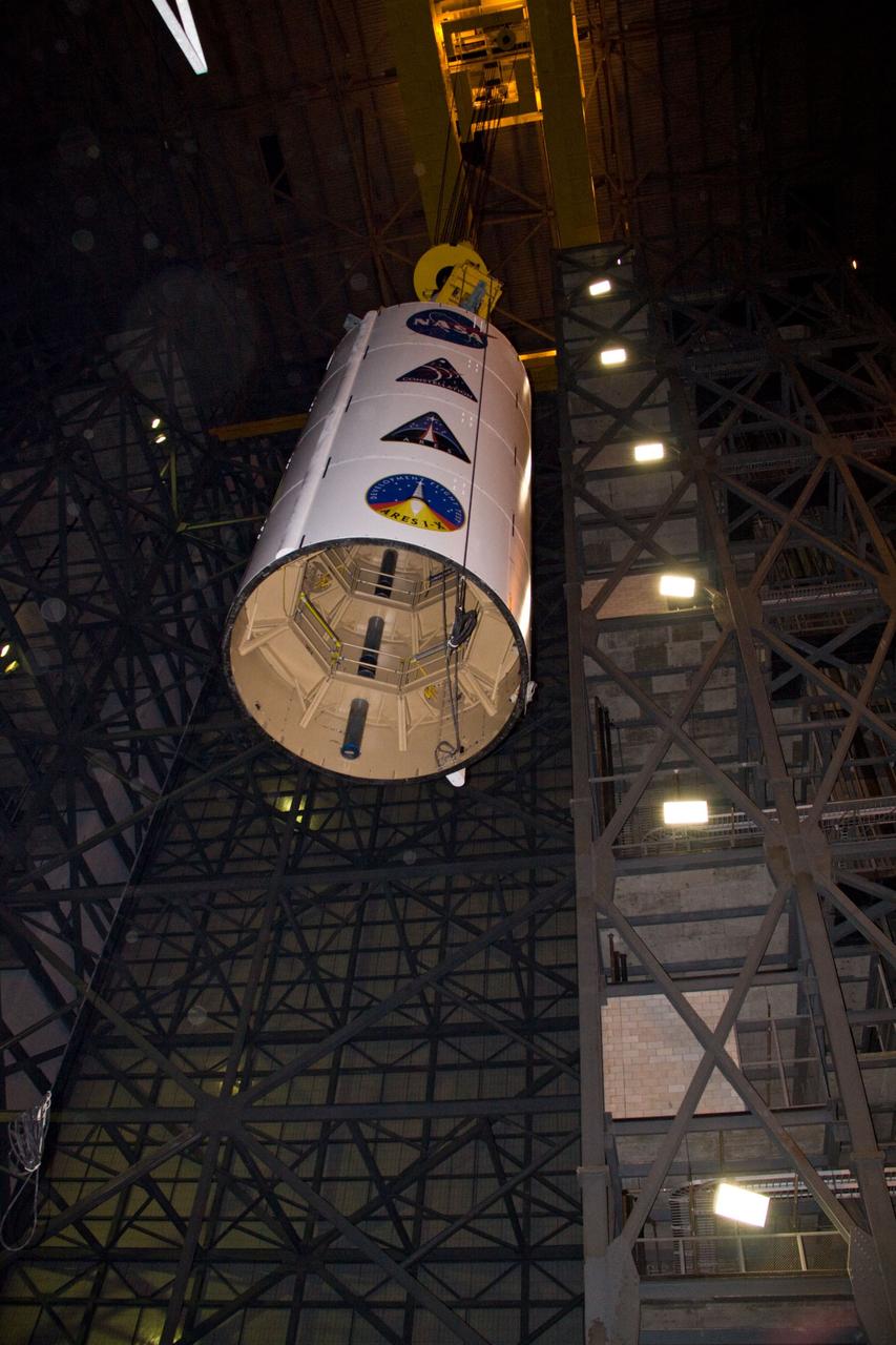 CAPE CANAVERAL, Fla. – In NASA Kennedy Space Center's Vehicle Assembly Building, a crane lowers the Ares I-X Super Stack 3 into High Bay 4. There it will be integrated with Super Stack 2. The upper stage comprises five super stacks, which are integrated with the four-segment solid rocket booster first stage on the mobile launch platform. Ares I-X is the test vehicle for the Ares I, which is part of the Constellation Program to return men to the moon and beyond. The Ares I-X flight test is targeted for Oct. 31, pending formal NASA Headquarters approval. Photo credit: NASA/Jack Pfaller