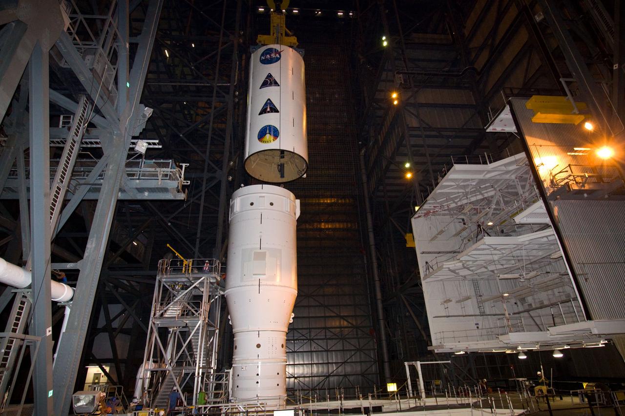 CAPE CANAVERAL, Fla. – In NASA Kennedy Space Center's Vehicle Assembly Building High Bay 4, a crane lowers the Ares I-X Super Stack 3 toward Super Stack 2 for integration. The upper stage comprises five super stacks, which are integrated with the four-segment solid rocket booster first stage on the mobile launch platform. Ares I-X is the test vehicle for the Ares I, which is part of the Constellation Program to return men to the moon and beyond. The Ares I-X flight test is targeted for Oct. 31, pending formal NASA Headquarters approval. Photo credit: NASA/Jack Pfaller