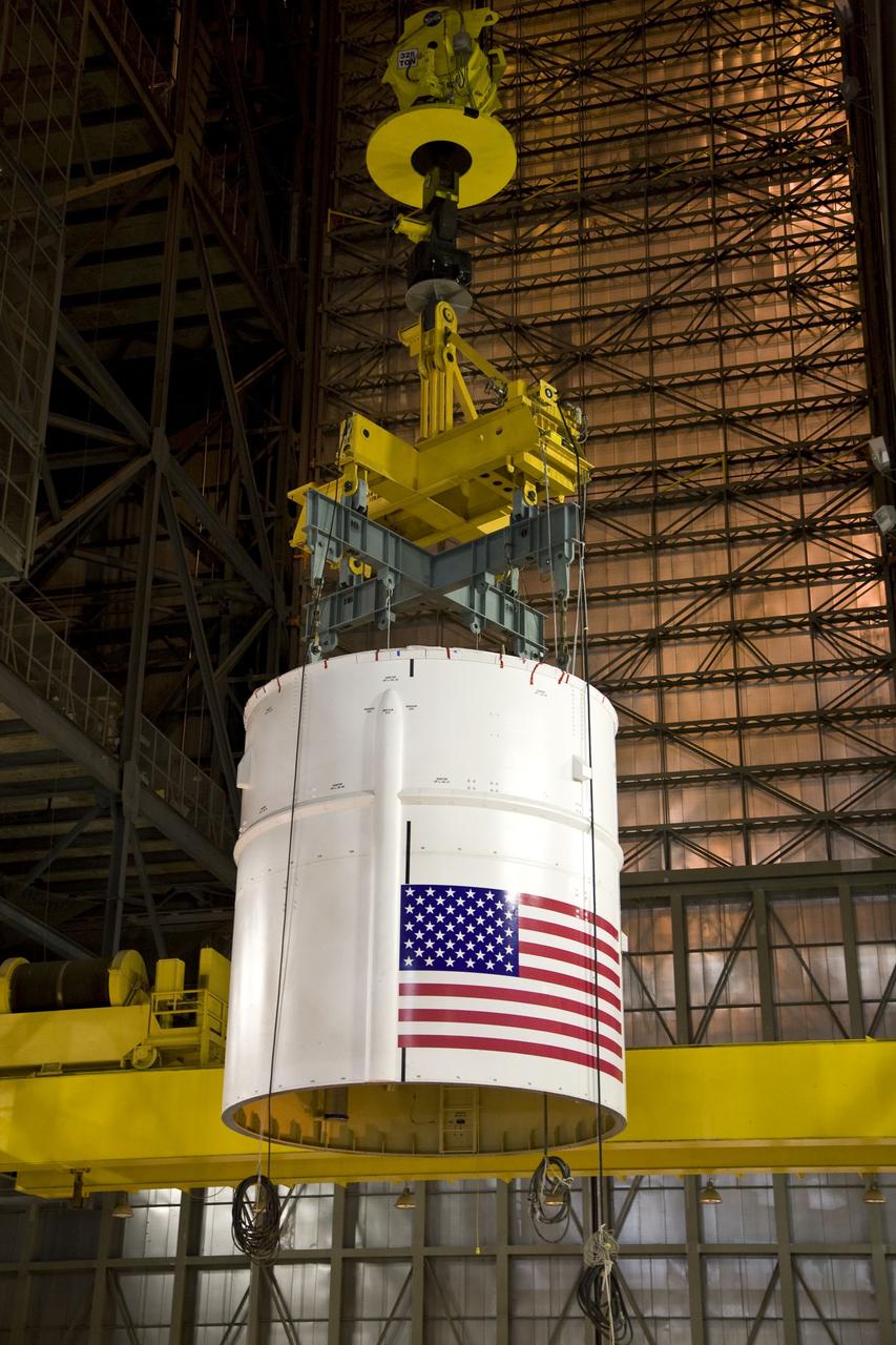CAPE CANAVERAL, Fla. – In the Vehicle Assembly Building's High Bay 4 at NASA's Kennedy Space Center in Florida, a crane moves the Ares I-X Super Stack 4 across the floor to High Bay 3 for integration with Super Stack 3.  Five super stacks make up the upper stage that will be integrated with the four-segment solid rocket booster first stage on the mobile launch platform.  Ares I-X is the test vehicle for the Ares I, which is part of the Constellation Program to return men to the moon and beyond. The Ares I-X flight test is targeted for  Oct. 31, pending formal NASA Headquarters approval. Photo credit: NASA/Dimitri Gerondidakis