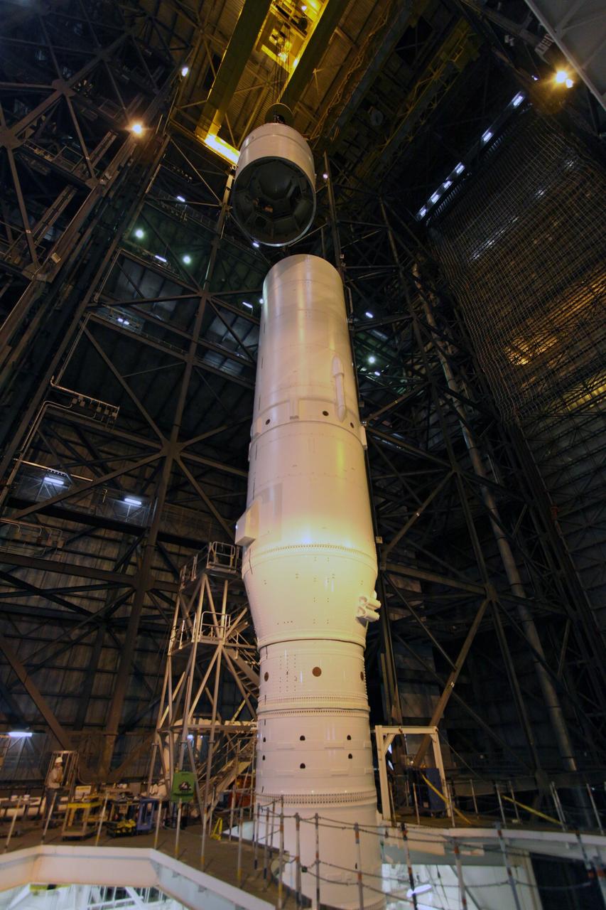 CAPE CANAVERAL, Fla. –In the Vehicle Assembly Building's High Bay 3, a crane lowers the Ares I-X Super Stack 4 toward Super Stack 3 for integration. Five super stacks make up the upper stage that will be integrated with the four-segment solid rocket booster first stage on the mobile launch platform. Ares I-X is the test vehicle for the Ares I, which is part of the Constellation Program to return men to the moon and beyond. The Ares I-X flight test is targeted for Oct. 31, pending formal NASA Headquarters approval. Photo credit: NASA/Jack Pfaller