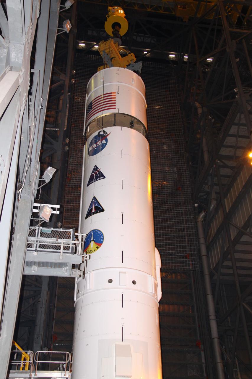 CAPE CANAVERAL, Fla. – In the Vehicle Assembly Building's High Bay 3, a crane lowers the Ares I-X Super Stack 4 toward Super Stack 3 for integration. Five super stacks make up the upper stage that will be integrated with the four-segment solid rocket booster first stage on the mobile launch platform. Ares I-X is the test vehicle for the Ares I, which is part of the Constellation Program to return men to the moon and beyond. The Ares I-X flight test is targeted for Oct. 31, pending formal NASA Headquarters approval. Photo credit: NASA/Jack Pfaller