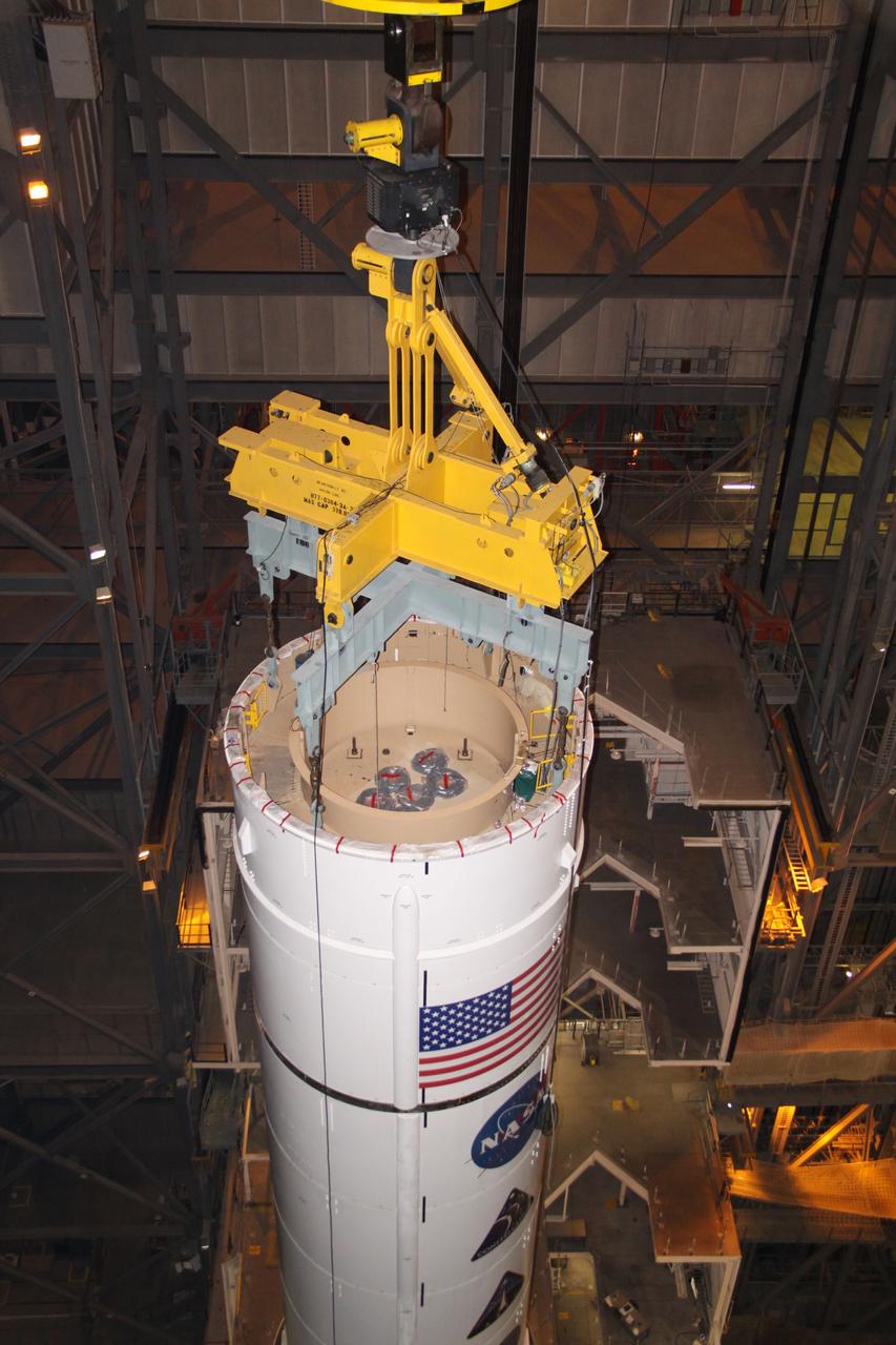 CAPE CANAVERAL, Fla. – In the Vehicle Assembly Building's High Bay 3, a crane lowers the Ares I-X Super Stack 4 onto Super Stack 3 for integration. Five super stacks make up the upper stage that will be integrated with the four-segment solid rocket booster first stage on the mobile launch platform. Ares I-X is the test vehicle for the Ares I, which is part of the Constellation Program to return men to the moon and beyond. The Ares I-X flight test is targeted for Oct. 31, pending formal NASA Headquarters approval. Photo credit: NASA/Jack Pfaller