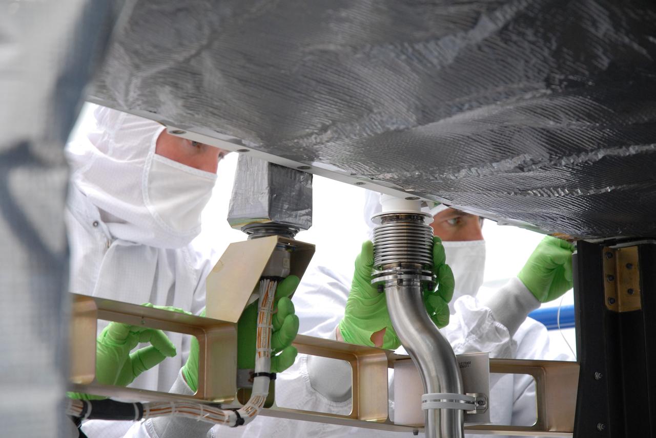 CAPE CANAVERAL, Fla. – In the Astrotech payload processing facility in Titusville, Fla. , technicians check equipment on the STSS Demonstrator SV-1 spacecraft after it was lowered onto the orbital insertion system. The spacecraft is a midcourse tracking technology demonstrator, part of an evolving ballistic missile defense system. STSS is capable of tracking objects after boost phase and provides trajectory information to other sensors. It will be launched by NASA for the Missile Defense Agency in late summer.  Photo credit: NASA/Tim Jacobs  (Approved for Public Release 09-MDA-4800 [30 July 09] )