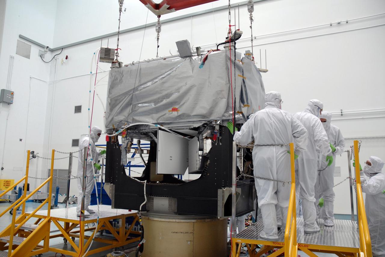 CAPE CANAVERAL, Fla. – In the Astrotech payload processing facility in Titusville, Fla. , technicians get ready to remove the overhead crane from the STSS Demonstrator SV-1 spacecraft.  The spacecraft is a midcourse tracking technology demonstrator, part of an evolving ballistic missile defense system. STSS is capable of tracking objects after boost phase and provides trajectory information to other sensors. It will be launched by NASA for the Missile Defense Agency in late summer.  Photo credit: NASA/Tim Jacobs  (Approved for Public Release 09-MDA-4800 [30 July 09] )